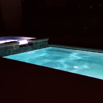Clear Water Pools - Night view of pool and hot tub with rotating colored lights and waterfall feature. - Masonry/Concrete Near Me Clear Water Pools - Night view of pool and hot tub with rotating colored lights and waterfall feature. - Masonry/Concrete Near Me