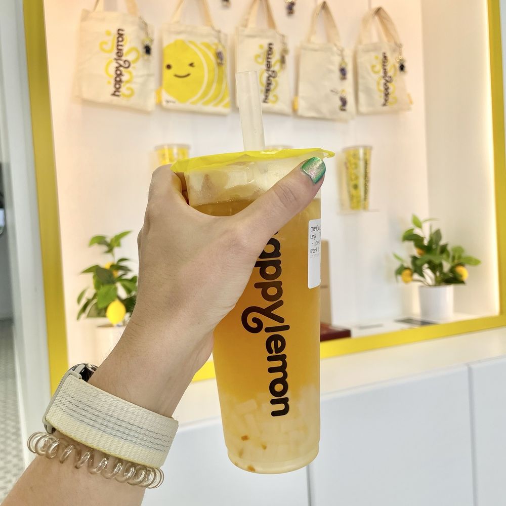 Yuzu Lemon Green Tea with Happy Lemon merch in the background (keychains, mini tote bags, and tumblers) Yuzu Lemon Green Tea with Happy Lemon merch in the background (keychains, mini tote bags, and tumblers)