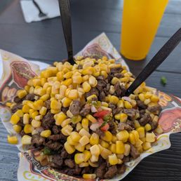 Carne asada potato with corn and pico de gallo.