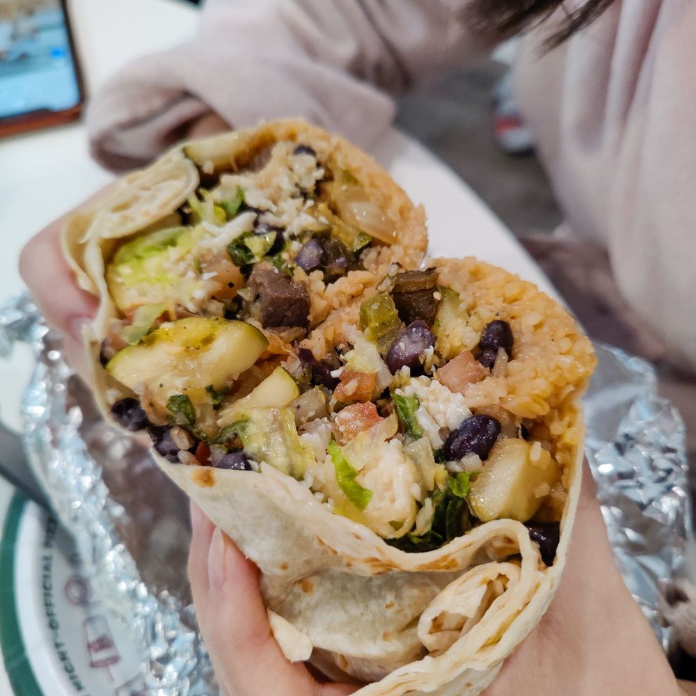 Santa Fe Burrito Grill - a person holding a burrito - Mexican Near Me - Weymouth, Massachusetts Santa Fe Burrito Grill - a person holding a burrito - Mexican Near Me - Weymouth, Massachusetts