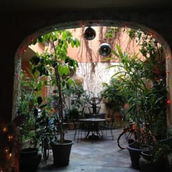 St. Philip French Quarter Apts - The courtyard was magical at night with all the holiday lights  wrapped around the columns, trees and antiques.