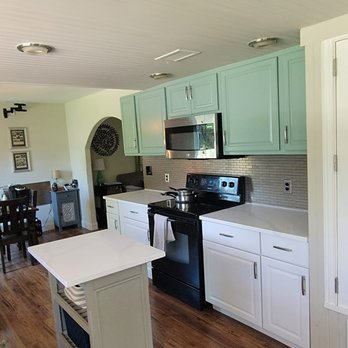 Confianza Contracting - a kitchen with white cabinets and black appliances - General Contractors Near Me - Austin, Texas