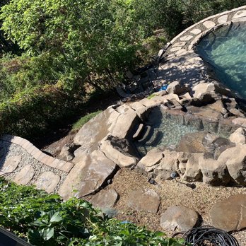 Modern Era Landscape - a pool surrounded by rocks - Landscaping Near Me Modern Era Landscape - a pool surrounded by rocks - Landscaping Near Me