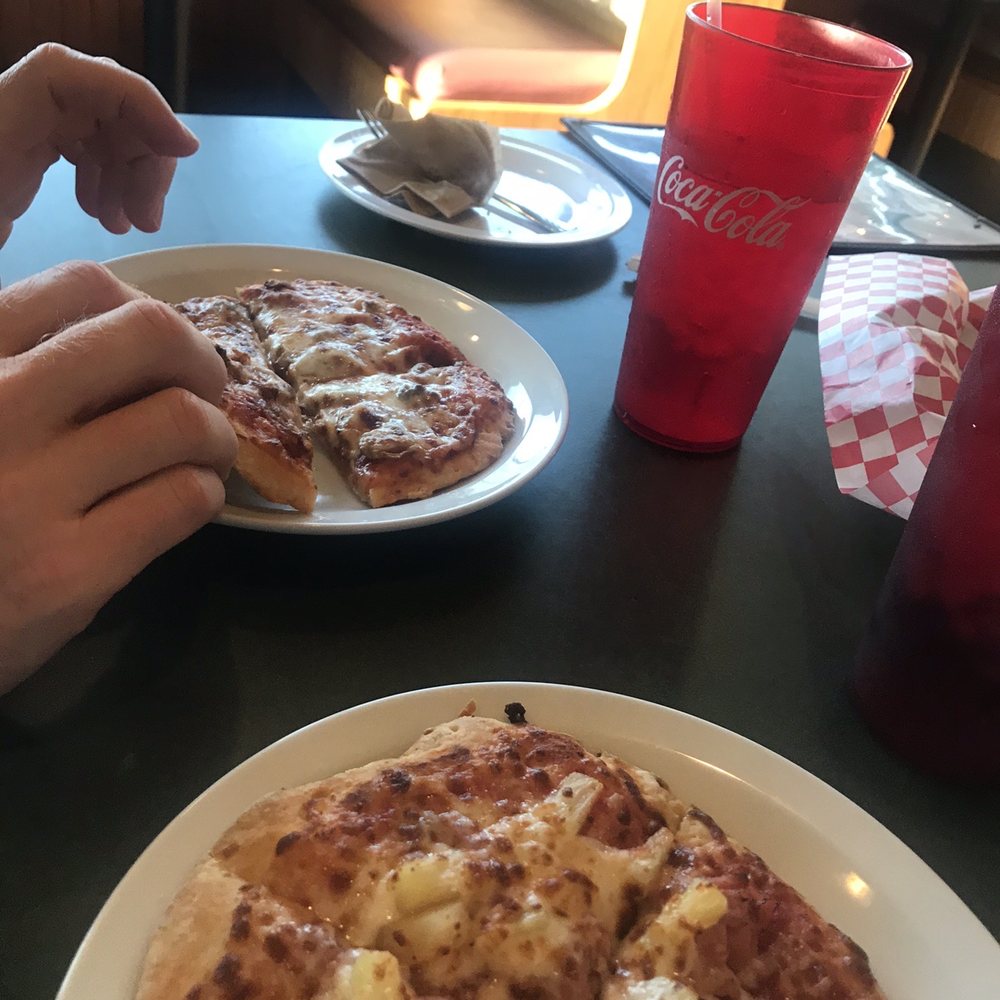 a person taking a slice of pizza a person taking a slice of pizza