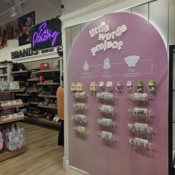 Uncharted - Bracelet and accessory display at Uncharted in Oak Brook, IL, featuring a pink sign for the 'little words project' and organized jewelry on hooks. - Accessories Near Me - Oak Brook, Illinois