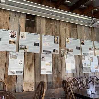 Amis Mill Eatery - a wooden wall with posters on it - Southern Near Me - Rogersville, Tennessee