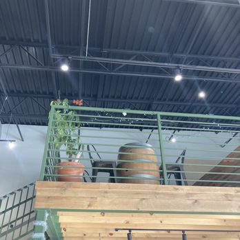 Chill Coffee and Wine Bar - Loft area with green railing and wine barrel table. - Coffee & Tea Near Me - Arlington, Texas