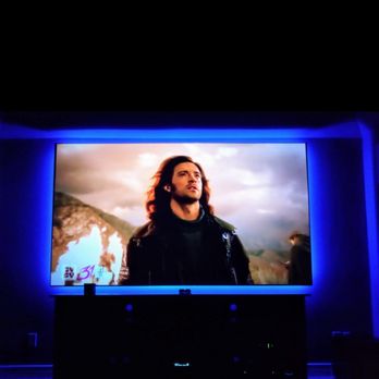 AV Hometronics - Media room featuring a color-changing LED-lit screen paired with a 4K projector for a vibrant and immersive viewing experience. - Home Theatre Installation Near Me - Houston, Texas AV Hometronics - Media room featuring a color-changing LED-lit screen paired with a 4K projector for a vibrant and immersive viewing experience. - Home Theatre Installation Near Me - Houston, Texas