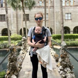 My daughter and new grandson taking a stroll on the bridge over a koi filled pond as various artists capture scenes in time.