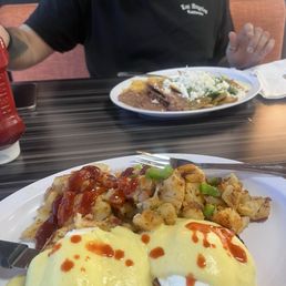 Egg Benedict with home potatoes. Green Chilaquiles & eggs with rice and beans