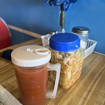 Pupuseria Comalapa - a cup of hot sauce next to a jar of soup - Salvadoran Near Me - Bellflower, California
