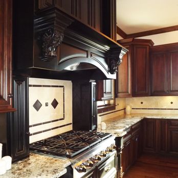 Robinett Construction - a kitchen with dark wood cabinets and marble countertops - General Contractors Near Me - Mexico, Missouri Robinett Construction - a kitchen with dark wood cabinets and marble countertops - General Contractors Near Me - Mexico, Missouri