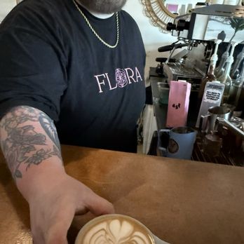 Flora Coffee - A very talented barista giving me a beautiful pour with oat milk - Coffee & Tea Near Me - Austin, Texas