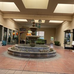 Resturant tucked back away from parking lot. Behind a fountain.