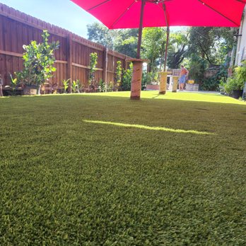 Artificial Grass & Paver Pros - a backyard with a red umbrella - Landscaping Near Me - St. Petersburg, Florida Artificial Grass & Paver Pros - a backyard with a red umbrella - Landscaping Near Me - St. Petersburg, Florida