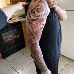 Loose Cannon Tattoo & Piercing - Koi fish with Roman numerals and flowers.