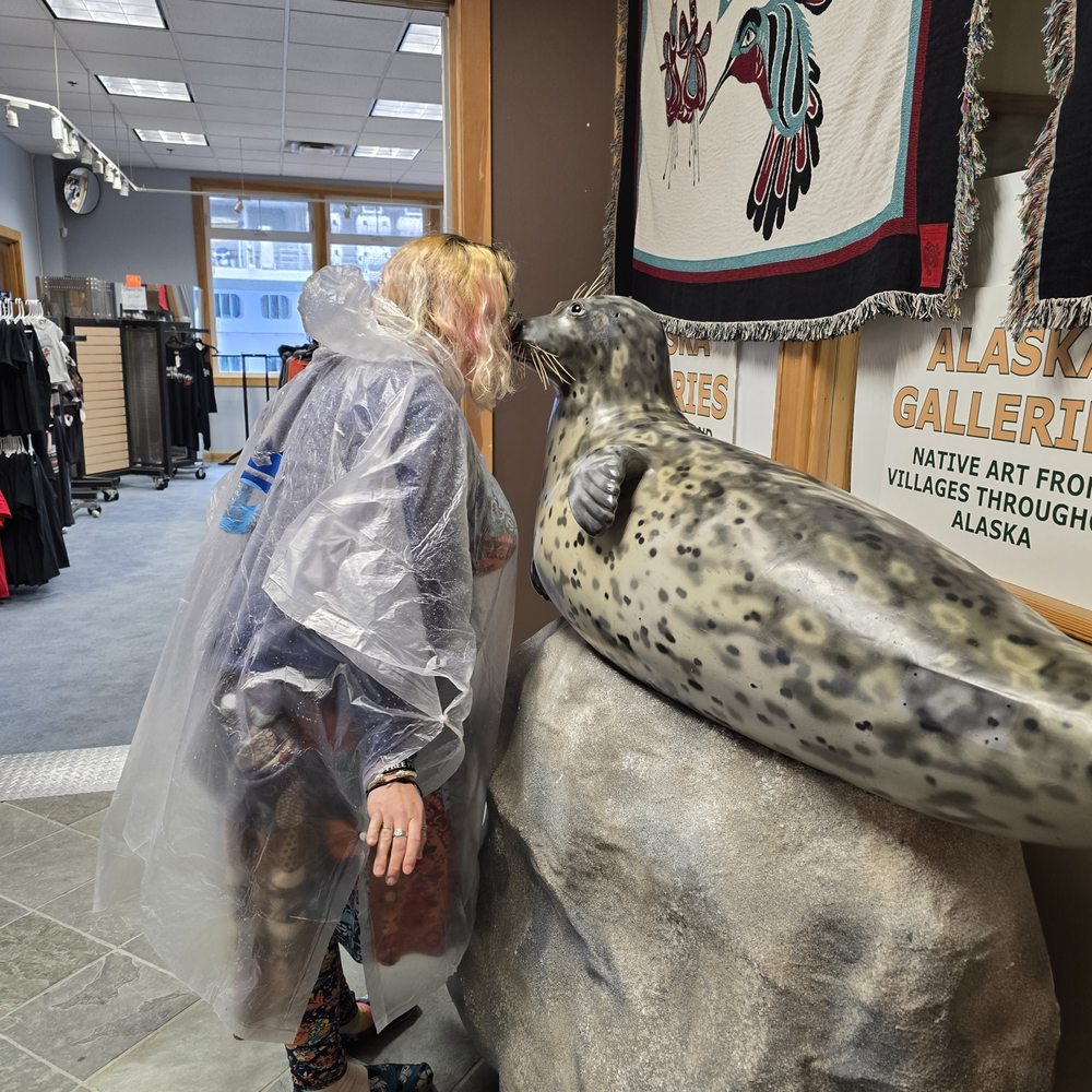Lady kissing seal sculpture in front of shop Lady kissing seal sculpture in front of shop