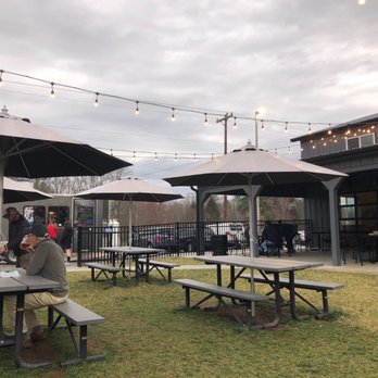 Burning Blush Brewery - Spacious seating with umbrellas to keep the sprinkles away on this showery saint patty's day. - Breweries Near Me - Mills River, North Carolina