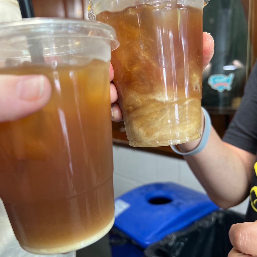 two people holding drinks two people holding drinks