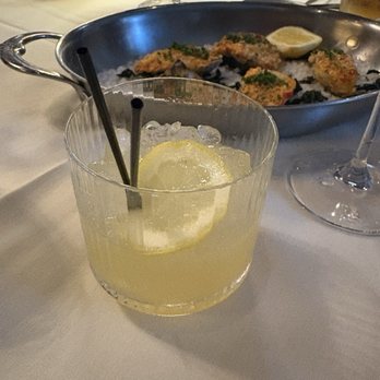 Adalina Prime - Bourbon peach smash with OYSTERS and TIGER BREAD in the background. - Steakhouses Near Me - Chicago, Illinois Adalina Prime - Bourbon peach smash with OYSTERS and TIGER BREAD in the background. - Steakhouses Near Me - Chicago, Illinois