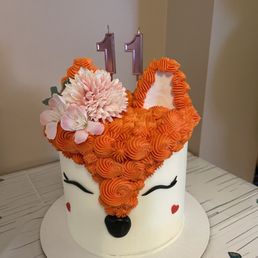 a white cake with orange icing and flowers on top a white cake with orange icing and flowers on top