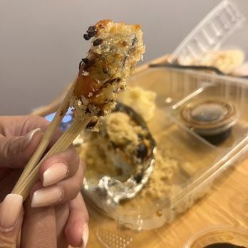 Sushi Sake Hammocks - a person holding a piece of food - Sushi Bars Near Me - Miami, Florida Sushi Sake Hammocks - a person holding a piece of food - Sushi Bars Near Me - Miami, Florida