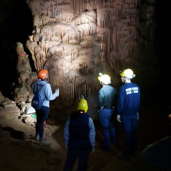 Fountain Cave Adventure Tours - Dana (left) commenting on a magnificient column formation, twice the height of what is shown, while the rest of the group looks on. - Historical Tours Near Me - Grottoes, Virginia