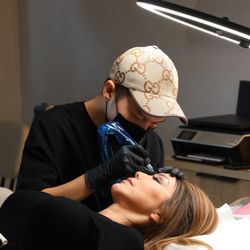 Inked VIP Studio - Detailed brow procedure with professional tools.