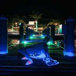 a man laying on a surfboard at night