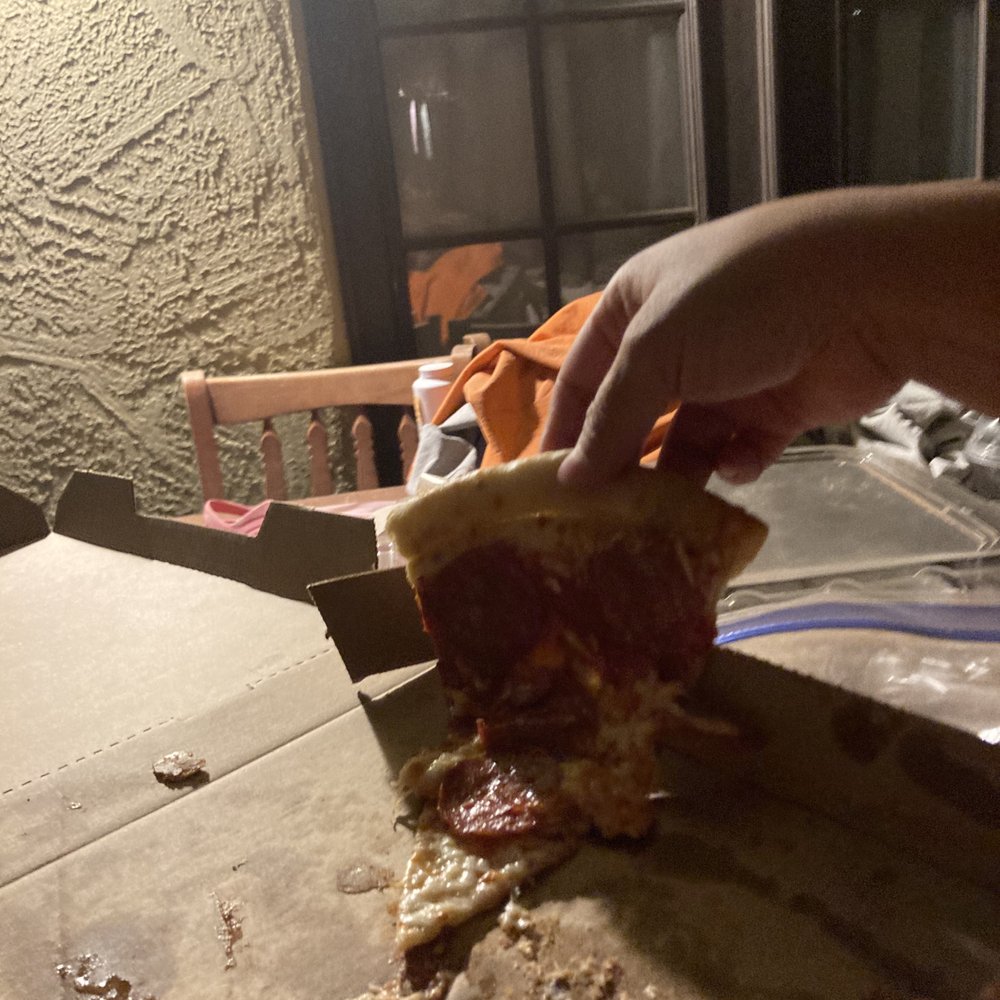 Little Caesars - a person taking a slice of pizza - Pizza Near Me - Coolidge, Arizona Little Caesars - a person taking a slice of pizza - Pizza Near Me - Coolidge, Arizona