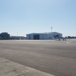 McGregor Executive Airport - Coming off of taxiway, large white building is a maintenance facility,  brick building under trees is the FBO.