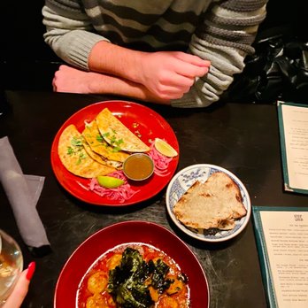 Stepchld - a man sitting at a table with plates of food - New American Near Me - Minneapolis, Minnesota