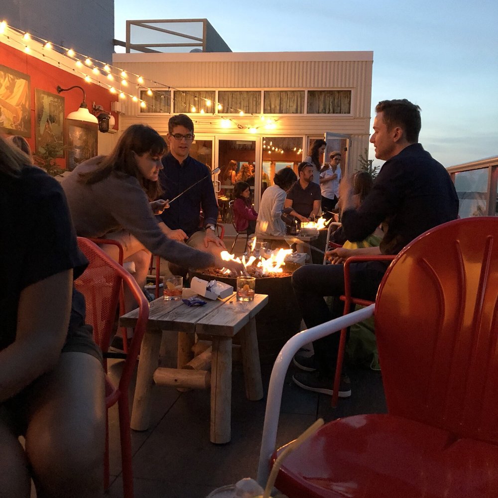 Camp Trippalindee - Patio in the evening with s'mores being roasted! - Bars Near Me - Madison, Wisconsin