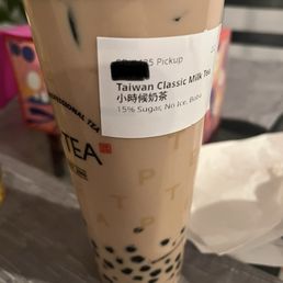 Taiwan Classic Milk Tea - A tall plastic cup of Taiwan classic milk tea with black tapioca pearls at the bottom, labeled for pickup, with no ice and 15% sugar.