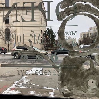 Cake Bar - Window view - A glass window features painted artwork and business details, with a view of parked cars and buildings on a city street outside. - Food Stands Near Me - Syracuse, New York