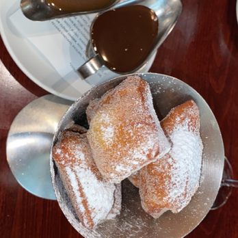 The Bay House - Crescent city beignets comes with chocolate and bourbon caramel sauce. The chocolate tastes like dark chocolate. - Seafood Near Me - Naples, Florida The Bay House - Crescent city beignets comes with chocolate and bourbon caramel sauce. The chocolate tastes like dark chocolate. - Seafood Near Me - Naples, Florida