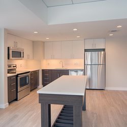 Vivo Apartments - Brand-new kitchens feature two-tone modern cabinets, quartz countertops and an island