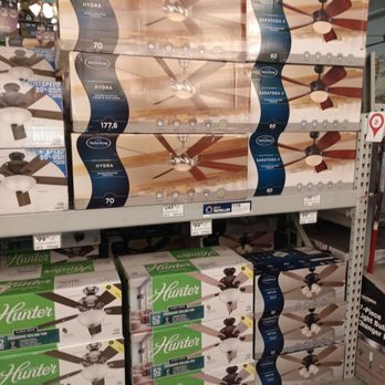Lowe's Home Improvement - Some of the fans I purchased at Lowe's - Multiple boxes of ceiling fans are arranged on store shelves at Lowe's, including models from Harbor Breeze and Hunter. The boxes display images of the fans, their specifications, and features. The shelves are organized with different fan styles and sizes, and price tags are visible below the products. The background shows store lighting and other hardware items. - Home Decor Near Me - Phoenix, Arizona