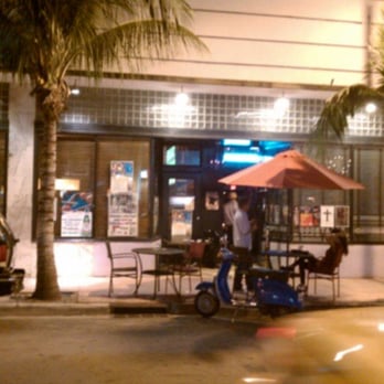 Blue Bar - a man on a scooter in front of a restaurant - Lounges Near Me - Miami Beach, Florida