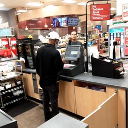 a man standing at a cash register a man standing at a cash register