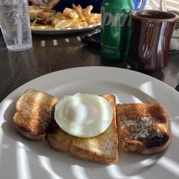 Poached egg and wheat toast in foreground, BLT and fries in the background