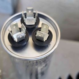 New capacitor, clearly labeled letters stamped next to terminals.