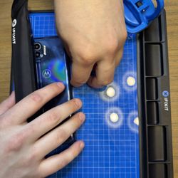 Schock’s Tech Stop - Using the iOpener to heat up the adhesive in order to remove the back cover. They don't just pop off like they used to!