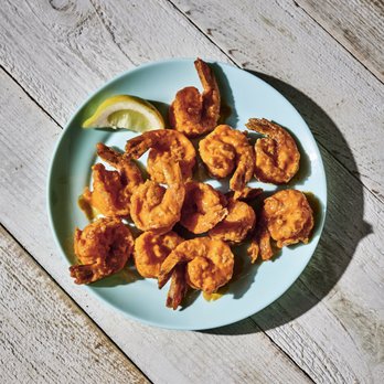 Hooters - a plate of fried shrimp with a lemon wedge - Sports Bars Near Me - Loveland, Colorado Hooters - a plate of fried shrimp with a lemon wedge - Sports Bars Near Me - Loveland, Colorado