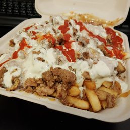 a tray of fries with cheese sauce and ketchup a tray of fries with cheese sauce and ketchup