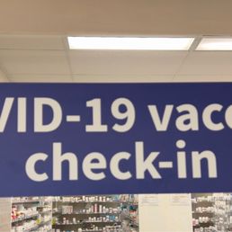 a blue sign that says covidid 19 vaccine check - in