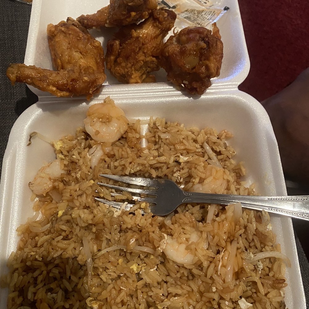 a tray of rice and chicken with a fork