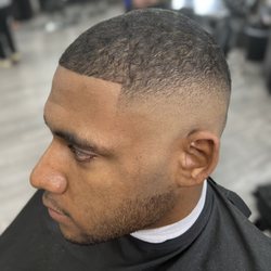Precision Hair Studio - High skin fade with the top trimmed with the grain.  Clean boxed-out shape-up