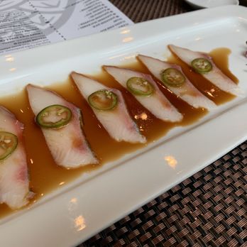 Tomo - KAMPACHI SERRANO 6 slices of kampachi sashimi, garlic, thinly sliced serrano pepper, yuzu soy sauce. - Japanese Near Me - Atlanta, Georgia Tomo - KAMPACHI SERRANO 6 slices of kampachi sashimi, garlic, thinly sliced serrano pepper, yuzu soy sauce. - Japanese Near Me - Atlanta, Georgia
