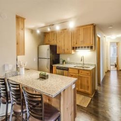 Campus Park - The kitchen with a marble counter top and wooden cabinets